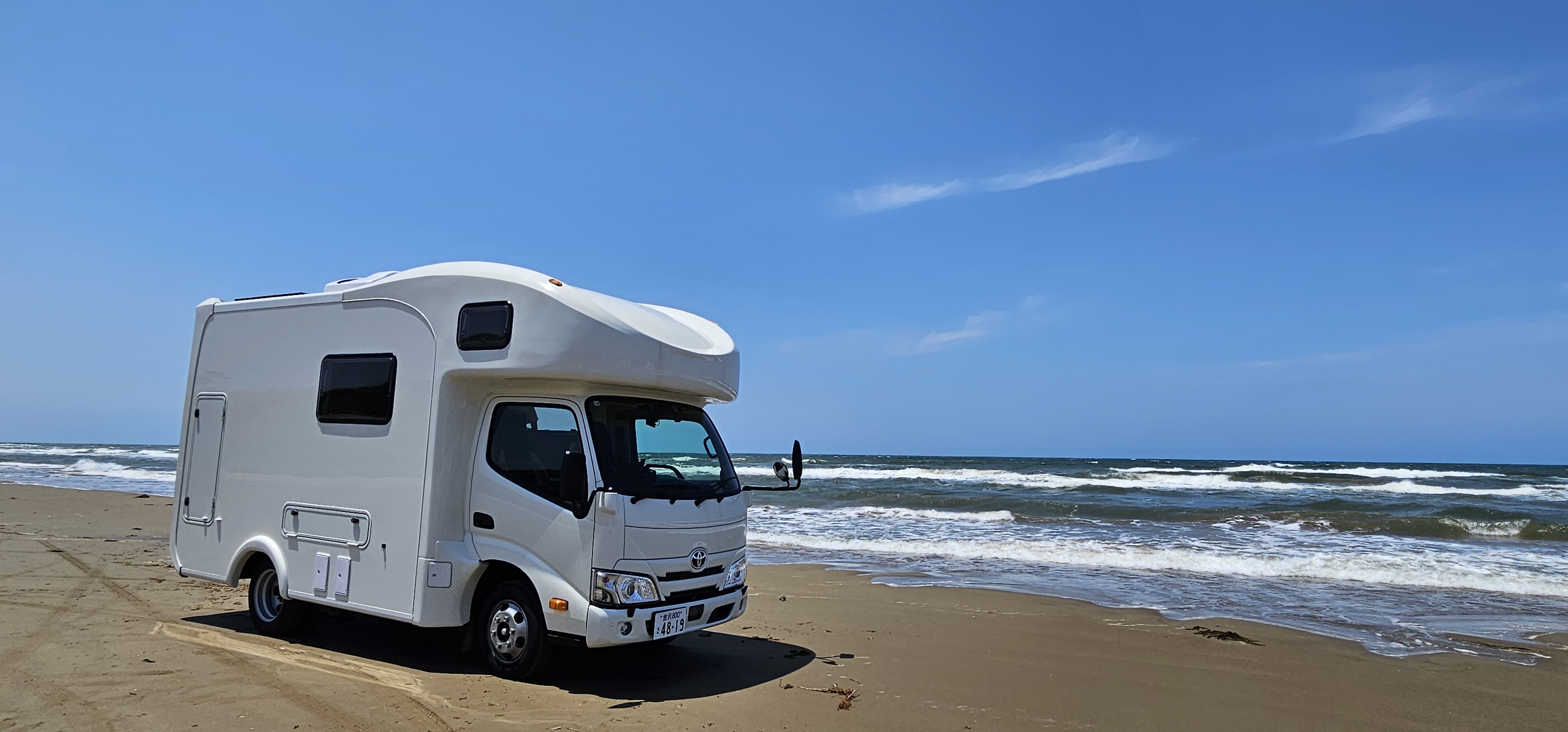 海辺に停まるeight caravanのキャンピングカー