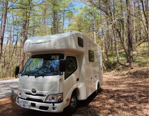 木立の中に停まるeight caravanのキャンピングカー