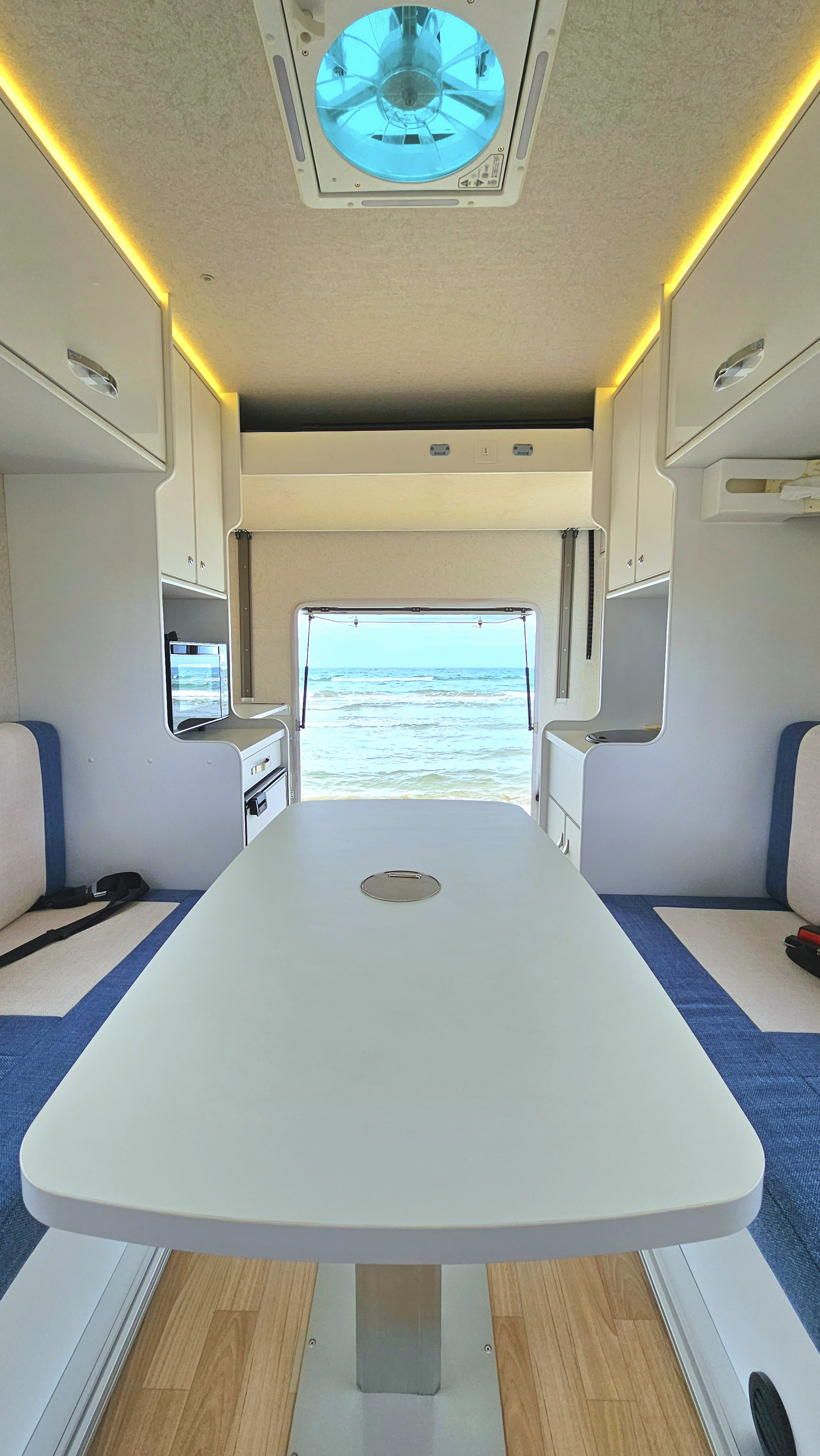 後部ドアから海が見えるeight caravanの車内